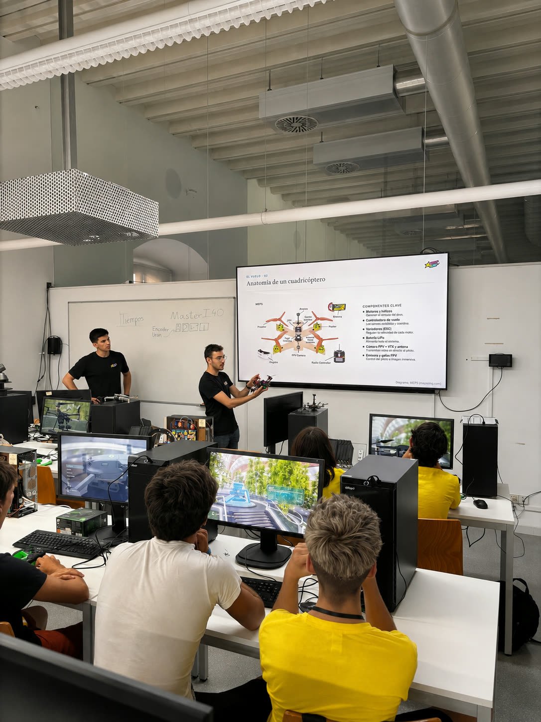 Un miembro del equipo mostrando un dron en mano durante la explicación de la anatomía de un cuadricóptero